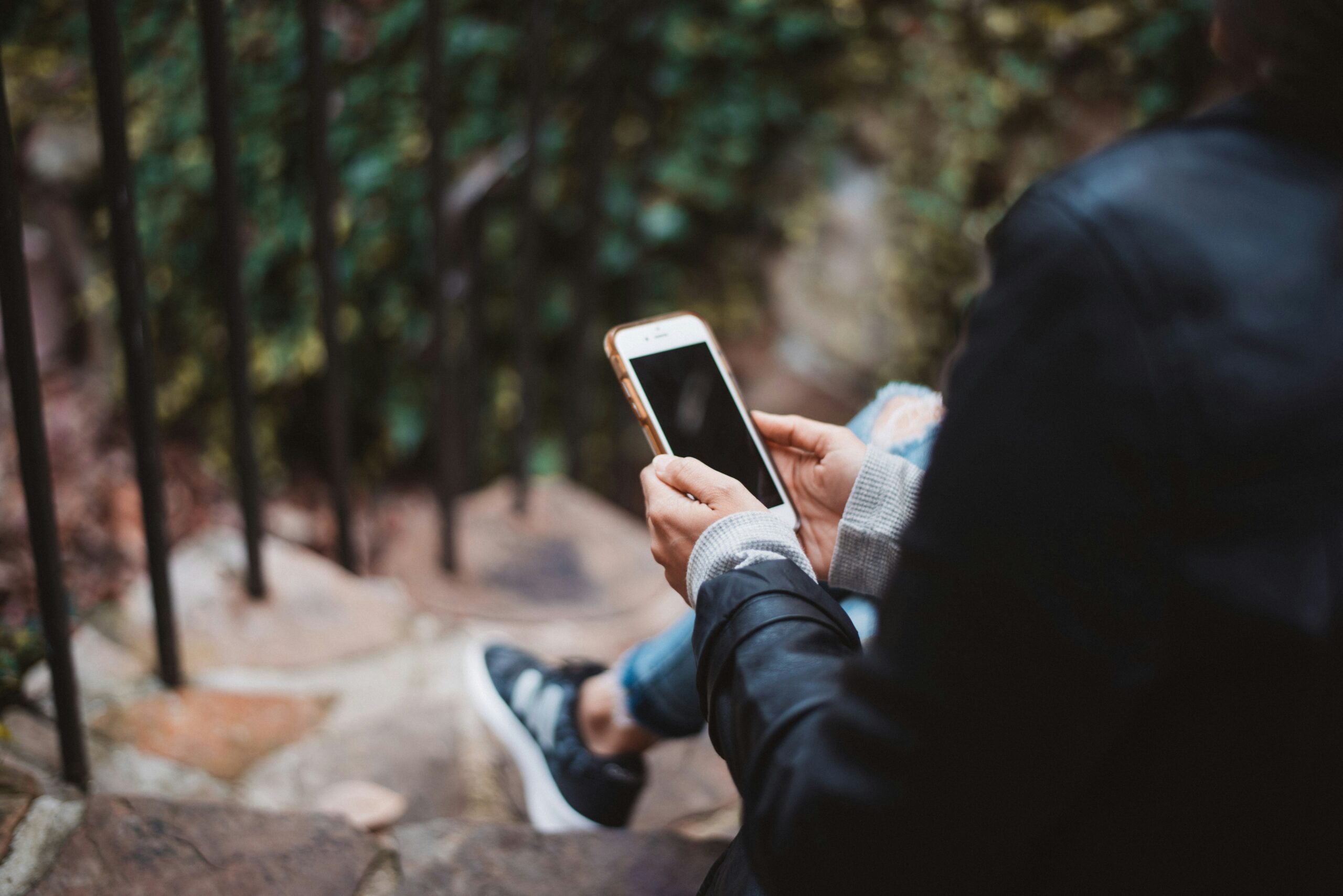 Teenager holding a smartphone, representing youth online activity and AI-powered age detection by Google.